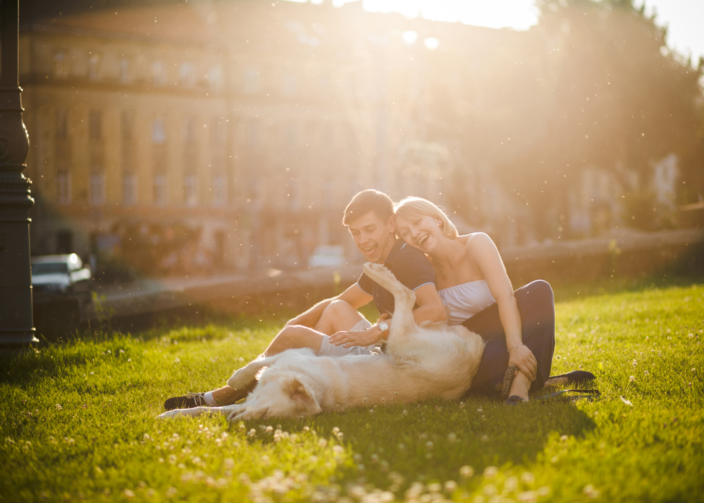Boy and girl with dog lay on grass